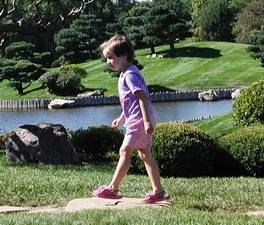 Mary Jane walking with arms and legs in opposition in the Chicago botanical garden. Photo credit Susan Kramer.